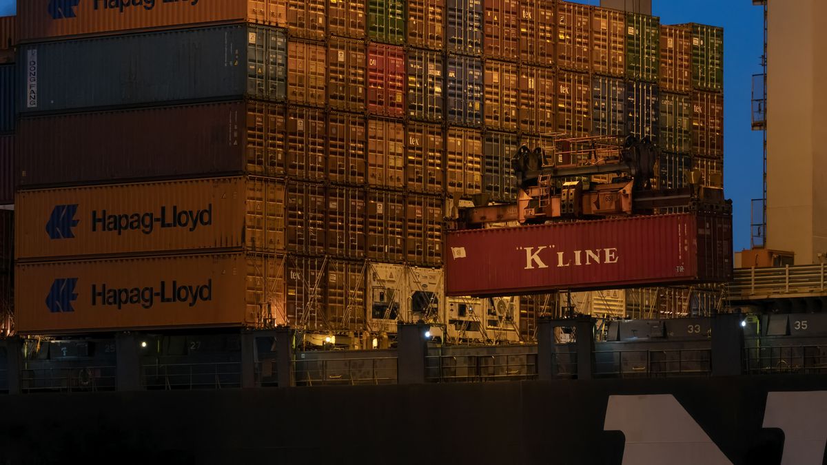 Crane loading container at dusk